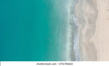 Sea waves on the beautiful beach aerial view drone video. Aerial view waves break on white sand beach at sunrise. Natural ocean waves landscape