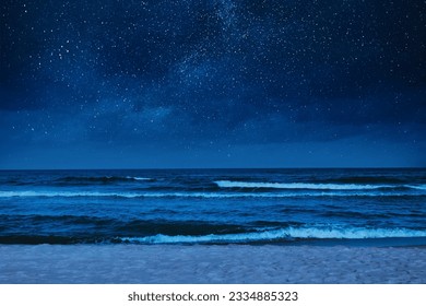 Sea waves rolling onto sandy beach under starry sky at night - Powered by Shutterstock