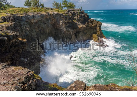 Sea waves splashing at the rocks in Barbados, green lush nature surrounding the beautiful sea water in a caribbean paradise island