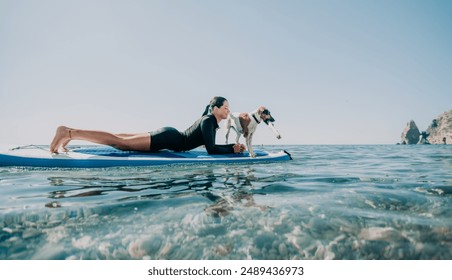 Sea woman sup. Silhouette of happy positive young woman with her dog, surfing on SUP board through calm water surface. Idyllic sunset. Active lifestyle at sea or river. Summer vacation with pets. - Powered by Shutterstock