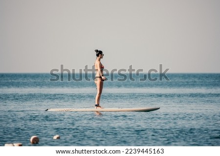 Sea woman sup. Silhouette of happy middle aged woman in rainbow