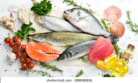 Seafood background: salmon, tuna, caviar, oysters, dorado fish and shellfish on a blue wooden background. Seafood. Flat lay.