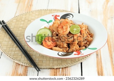 Seafood Kwetiau Goreng with Egg, Shrimps, Fish Meatball, and Lime. Stir Fry Char Kway Teow with Prawn On White Table 