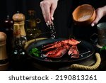 Seafood. Lobster claws on a plate in the hands of the chef. Food banner.