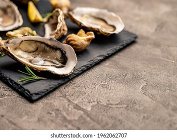 Seafood Luxury Set Of Fresh Oysters And Cooked Snails On Black Platter
