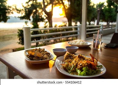 Seafood On Dining Table With Golden Light On Sunset At Restaurant Nearby The Beach