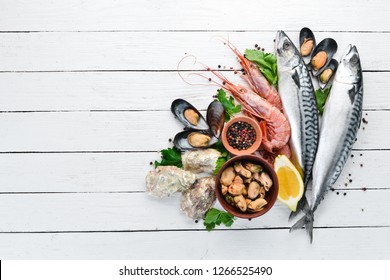 Seafood on a white wooden background. Fresh fish, shrimp, oysters and caviar. Top view. Free copy space.