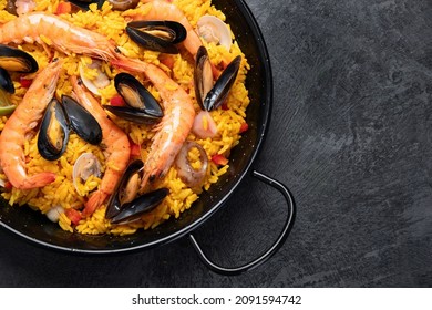 Seafood Paella on gray background. Mediterranean diet. Traditional food concept. Flat lay, top view, copy space