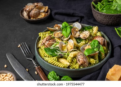 Seafood Pasta Salad With Vongole Clams, Fusilli, Spinach, Parmesan Cheese, Pine Nuts And Basil On Black Table. Healthy Food. Close Up. Mediterranean Diet Meal