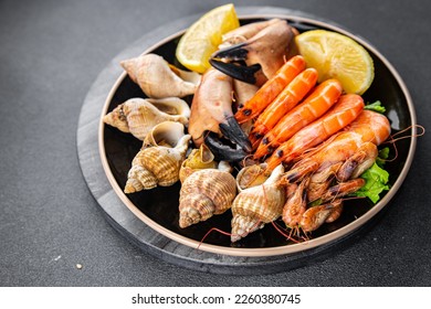 seafood plate assorted shrimps, crab claws, clams, rapan, trumpeter mollusk Takeaway healthy meal food snack on the table copy space food background rustic top view - Shutterstock ID 2260380745