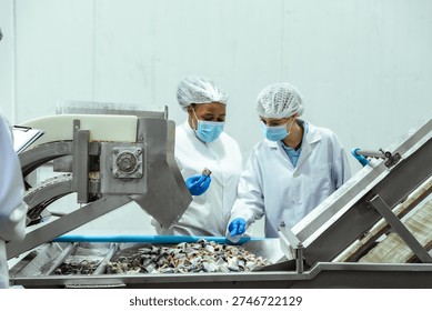 Seafood processing technicians evaluate product texture and appearance at preparation stage inside food manufacturing facility. Concept reflects safety standards, risk prevention and export certification readiness.