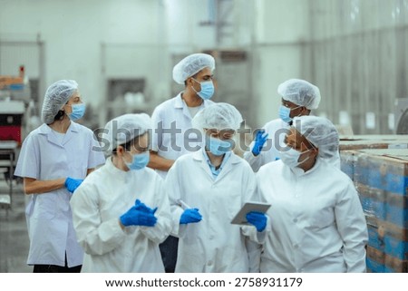 Seafood processing workers collaborate in factory environment reviewing operations and checking performance. Image highlights audit readiness, standardized procedures and industrial teamwork.