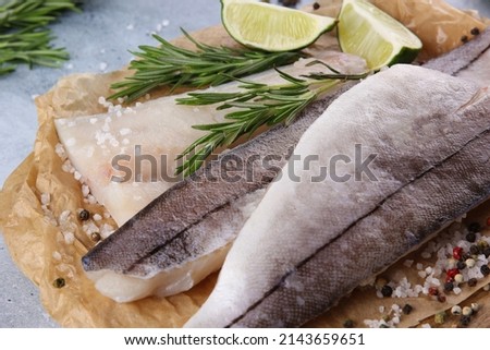 Seafood. Raw haddock fillet, white fish with lime, rosemary, chili pepper, herbs, spices and salt on a wooden board on a light grey background. Background image, copy space Foto stock © 