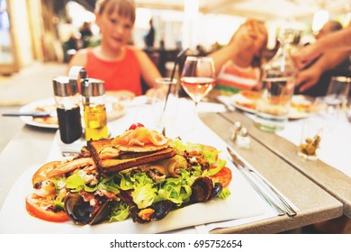 Seafood Salad Served In The Restaurant, Family Dining Outside During Summer Vacation On South Of France