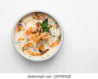 Seafood Stew (or Creamy Soup) In Ceramic Bowl. Shrimps (prawns), Mussles And Calamari Rings Stewed In Cream With Garlic And Green Parsley. Healthy Mediterranean Food Top View. White Background.