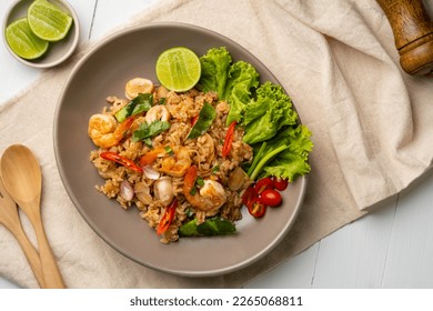 Seafood Tom Yum Fried Rice,Stir fried rice with shrimp and squid with chilli sauce on gray plate.Top view - Shutterstock ID 2265068811