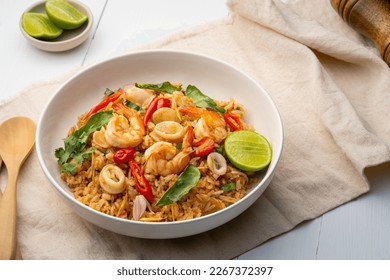 Seafood Tom Yum Fried Rice,Stir fried rice with shrimp and squid with chilli sauce on white plate - Powered by Shutterstock