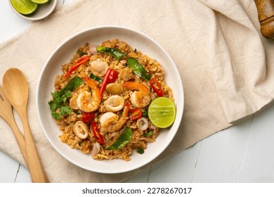 Seafood Tom Yum Fried Rice,Stir fried rice with shrimp and squid with chilli sauce on white plate.Top view