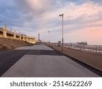 the seafront promenade in north Blackpool with the tower and town buildings in the distance and the north pier at low tide