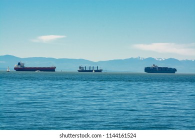 Seagoing Vessels Passing A Harbor. Ship Traffic To A Port. Congestion Of Shipping