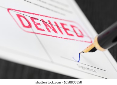 Seal denied stamped on a document and fountain pen. Macro shot. Soft focus. - Shutterstock ID 1058833358
