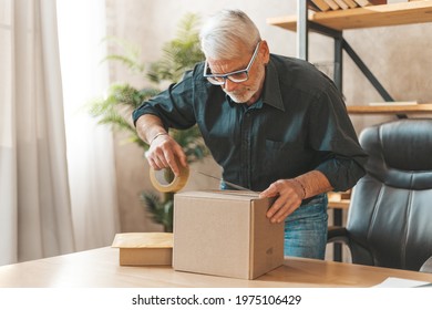 Seal the parcel. A grown man sends a box of goods by mail. Return of purchase to the online store. - Shutterstock ID 1975106429