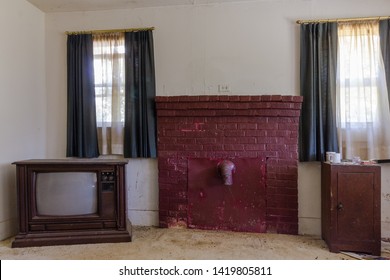 Sealed up brick fireplace and vintage television in an abandoned house in the deep south - Shutterstock ID 1419805811