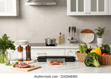 Sealer for vacuum packing with meat in plastic bag on white kitchen table - Powered by Shutterstock