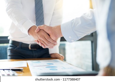 Sealing a deal! Business people shaking hands after Welcoming partners  finishing up a meeting or setting goals and planning way to success in the office