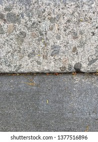 seam of two different types of concrete, one finished and another with a rough look and embedded rocks.