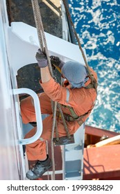 Seaman Ship Crew Working Aloft At Height Painting Ships Hull And Superstructure.