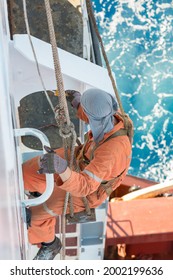 Seaman Ship Crew Working Aloft At Height Painting Ships Hull And Superstructure.