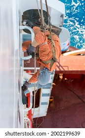 Seaman Ship Crew Working Aloft At Height Painting Ships Hull And Superstructure.