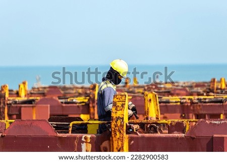Seaman working on deck of the container vessel. He is preparing ship to enter shipyard.