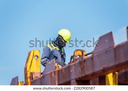 Seaman working on deck of the container vessel. He is preparing ship to enter shipyard.
