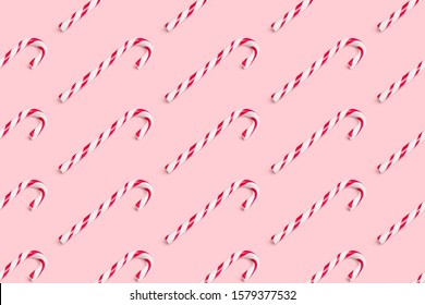 Seamless background pattern of christmas candy cane isolated on pink background