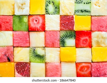 Seamless background pattern and texture of colourful fresh diced tropical fruit cubes arranged in a geometric pattern with melon, watermelon, banana, pineapple, strawberry, kiwifruit and grapefruit - Powered by Shutterstock