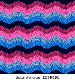 Seamless crochet zigzag pattern is crocheted with bright contrasting threads. Acrylic baby yarn. African style. Blue and pink color scheme.