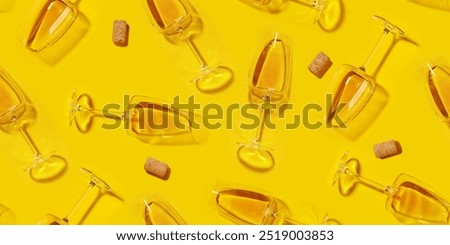 Seamless flat lay background with white wine glasses evenly arranged over a vibrant yellow backdrop, creating a bright and elegant visual