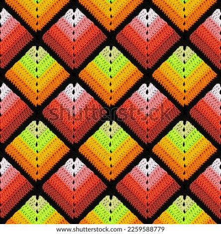 Seamless knitted pattern in the form of gradient rhombuses is crocheted with multi-colored threads. Patchwork style. Analog color combination.