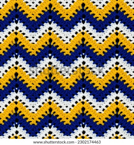 Seamless knitted pattern in the form of openwork zigzags crocheted with threads of contrasting colors. Acrylic baby yarn. African style.