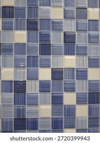 Seamless pattern of blue and white square mosaic tiles. Textured ceramic surface for swimming pool, bathroom, or kitchen backsplash design.