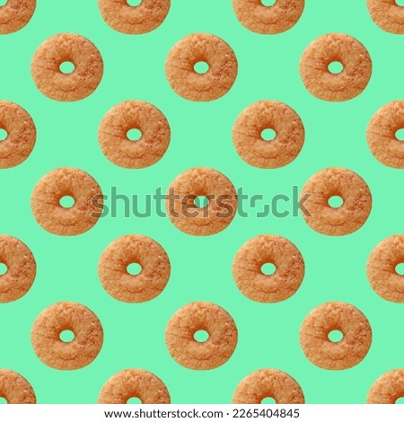 Seamless Pattern of Delectable Cinnamon Doughnut on Mint Green Colored Background