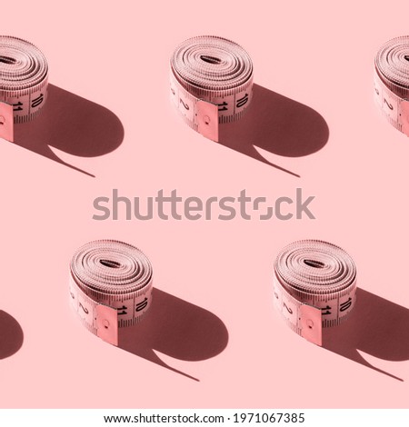 Seamless pattern with a tailor's ruler on a pink background. Endlessly repeating centimeter rolled into a roll with hard shadow. Pink rolled measuring tape with indicators in form of centimeters.