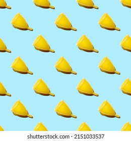 Seamless Pattern Of Yellow Menstrual Cups Isolated On A Blue Background. Women's Health Concept. Eco Friendly Concept. Zero Waste Concept.