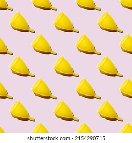 Seamless Pattern Of Yellow Menstrual Cups Isolated On A Pink Background. Women's Health Concept. Eco Friendly Concept. Zero Waste Concept.