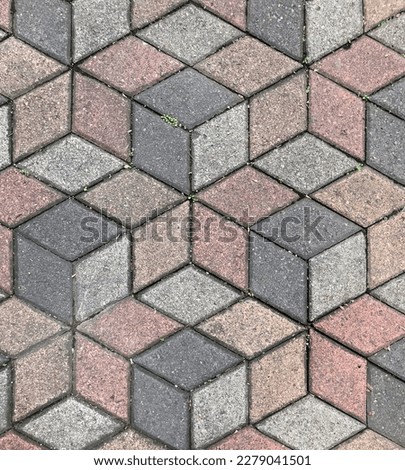 Seamless paving stone pavement texture in 3D geometrical cube or hexagonal pattern. Dark grey, pink, and grey color. Pavement texture background. Landscape stone pavement. No People.