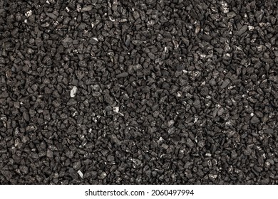 Seamless texture and full-frame background of coconut activated charcoal used as chemical adsorbent material. Close-up of black dry granular carbon .