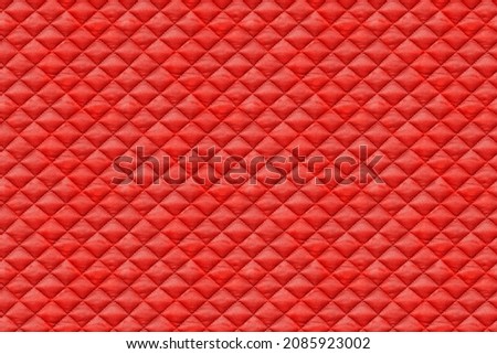 Seamless texture of red quilted fabric, cloth sewn into the cell, stitching. Texture of the blanket, red textile
