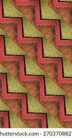 Seamless zigzag pattern created from aerial landscape textures, combining red pathways, green grass, and earthy soil tones. Bold geometric repeat ideal for backgrounds and design use